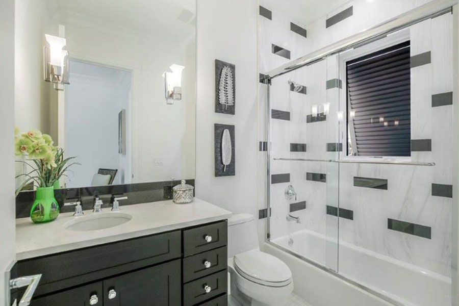 Guest bathroom with black and white color scheme, custom cabinetry and newly remodeled shower by Scholten Construction