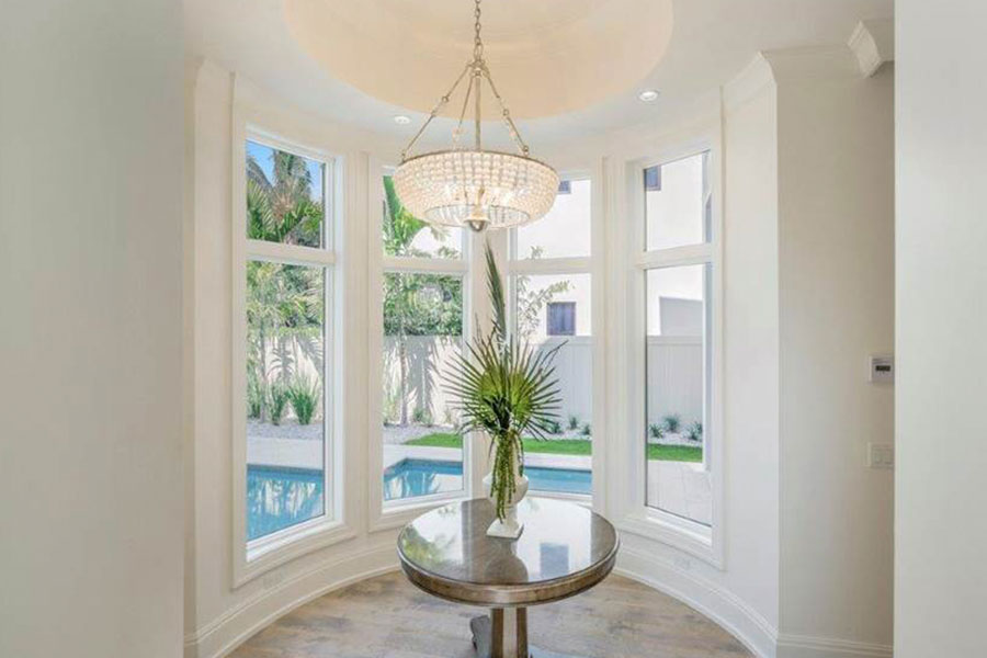 Bay window with custom chandelier lighting featuring Andersen high impact windows in Naples, Florida home by Scholten Construction