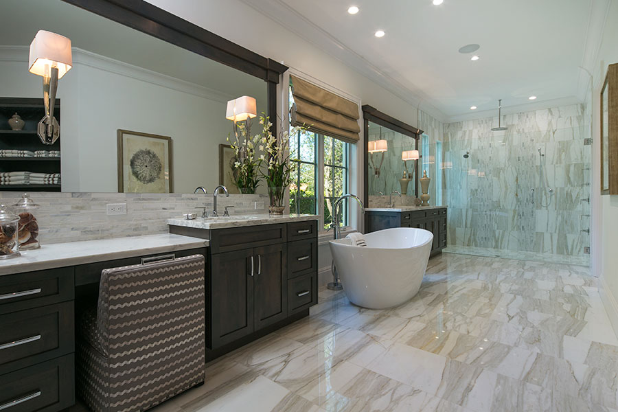 Spacious open concept master bathroom with light and warm tones with free standing bath tub by Scholten Construction